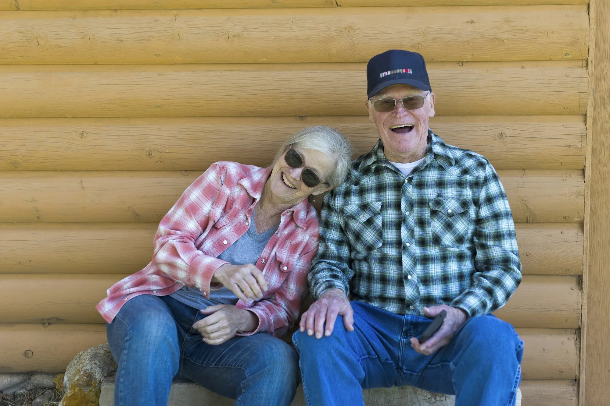 Retired couple laughing together on a cabin porch