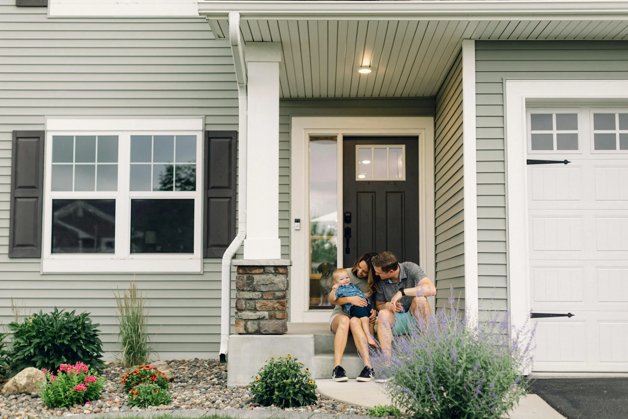 Couple sitting on the front steps of their home